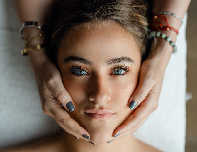 A woman receiving a soothing facial massage, promoting relaxation and rejuvenation in a tranquil setting.