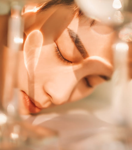 Close-up of a women with a blurred face area, wearing a sparkling dress.