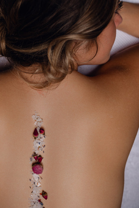 A woman adorned with vibrant flowers on her back, showcasing a unique and artistic floral arrangement.