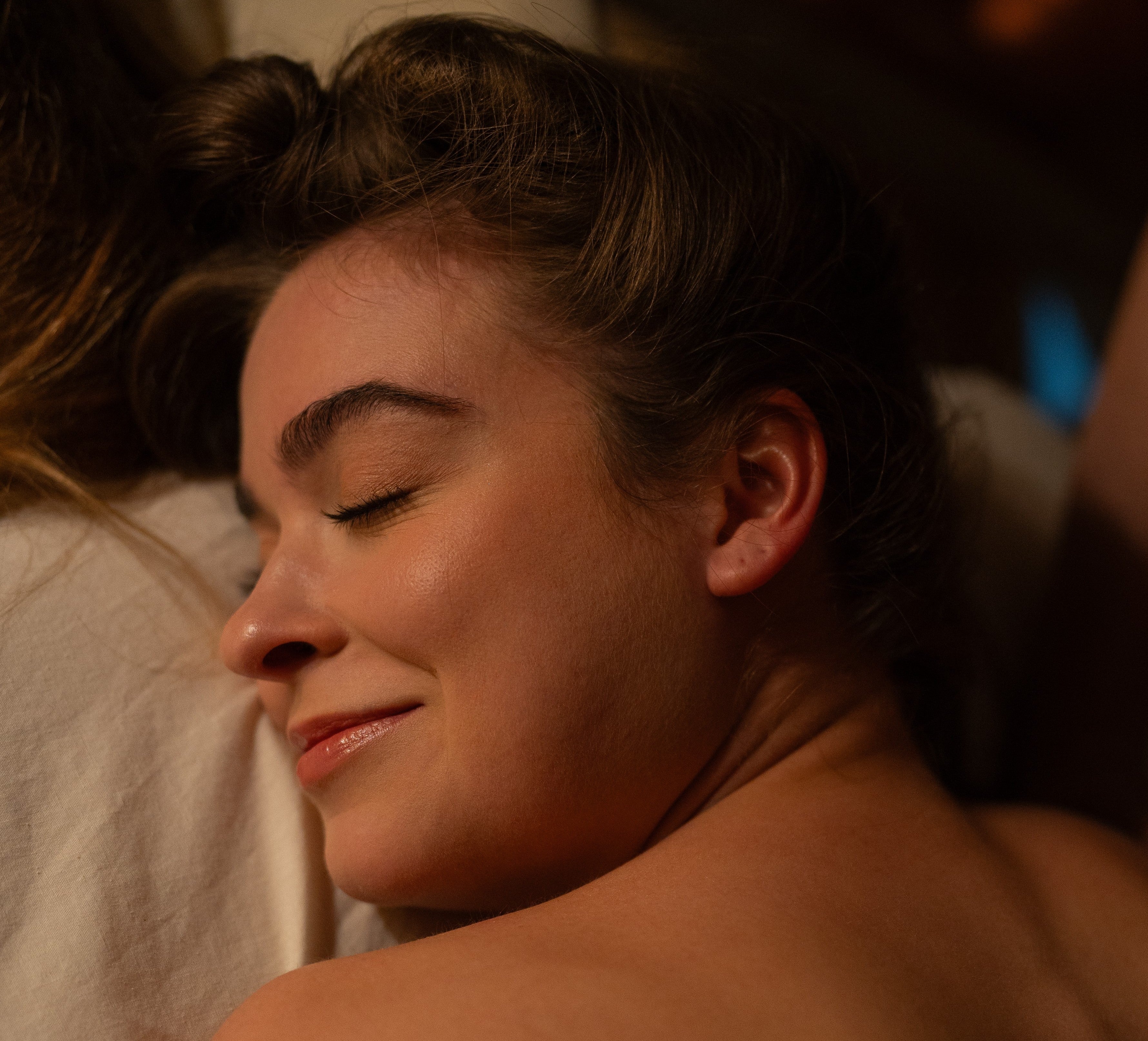 A woman reclines comfortably on a surface, appearing relaxed and at ease in her surroundings.